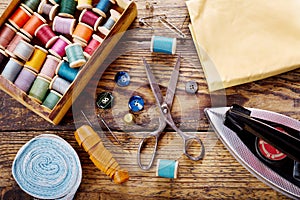 Sewing tools : scissors, bobbins with thread and iron