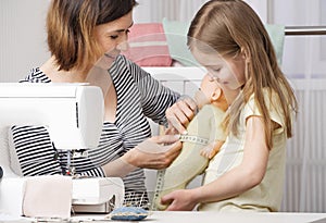 Sewing woman doing measurements on doll