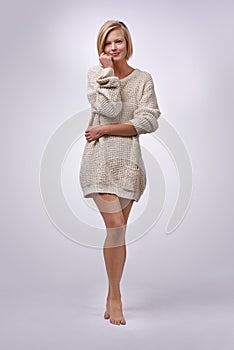 Sexiness in a sweater. Full length studio portrait of a beautiful young woman in a long sweater. photo