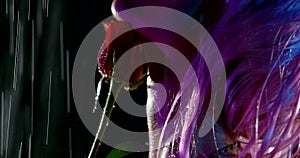 Sexual blonde woman is playing with red rose standing under rain at night time, closeup