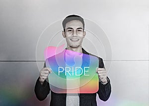 Sexual Minority and LGBT Concept. Happy Young Gay Smiling and Show Pride Text on Rainbow Card. Freedom of Expression