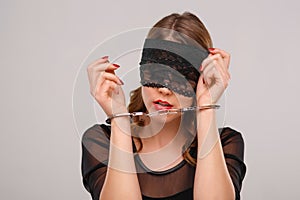 Sexual woman in eyeshade locked with handcuffs