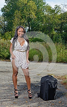 African-American woman in sundress with suitcase - travel