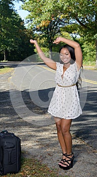 African-American woman in sundress with suitcase - travel