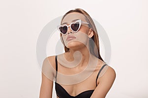 Sexy asian woman posing in black lingerie, sunglasses on white studio background