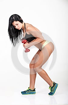 athletic woman with long hair working out with dumbbells.