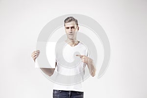 attractive man model is showing white empty space paper A4 for advert photo