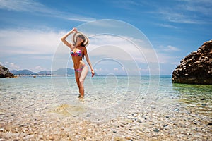 Sexy back of beautiful woman in bikini, creative hat and sunglasses on sea background. Sea coast near Kemer, Antalya, Turkey