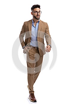 Sexy bearded man with glasses holding hand in pocket and walking