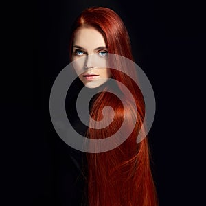 beautiful redhead girl with long hair. Perfect woman portrait on black background. Gorgeous hair and deep eyes Natural beauty