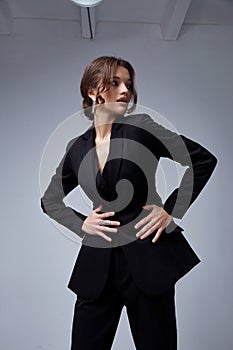 Sexy beautiful woman fashion glamour model brunette hair makeup wear black suit trousers jacket clothes office dress code casual photo