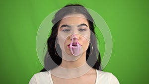 Sexy beauty girl chewing gum, blowing bubbles gum on green screen