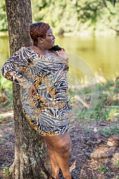 Sexy big black beautiful BBW model posing outdors in an animal print dress