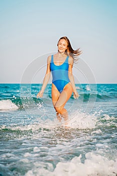 bikini body woman playful on paradise tropical beach having fun playing splashing water. Beautiful fit young girl on luxury t