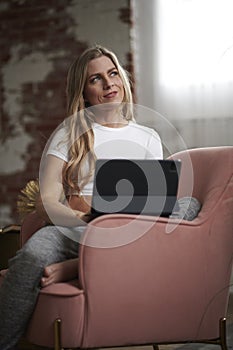 Sexy blond woman at home on tablet computer