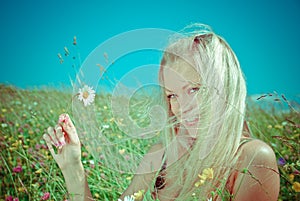 blonde on green meadow with camomile