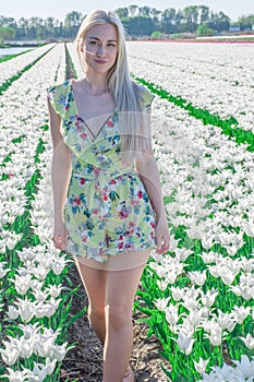 Sexy blonde at a photo shoot in a field of flowers and tulips Holland