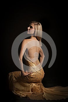 blonde woman in golden revealing evening dress photo