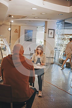 Sexy blonde woman ogle to bold man in cafe
