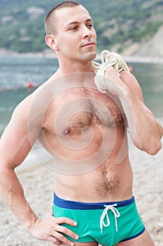 body builder is posing on the beach