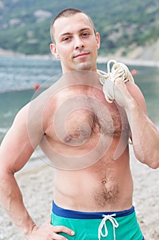 body builder is posing on the beach