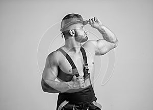 sexy builder in boilersuit. muscular man on construction site. handsome building worker in hard hat. labor day. athletic