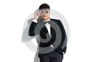 Sexy businessman is fixing his sunglasses