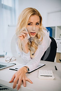 sexy businesswoman leaning on table and talking