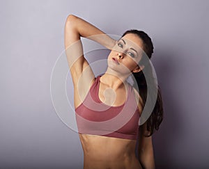 Sexy casual young woman in fashion sporty top posing on violet background with empty copy space. Closeup