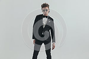 Sexy caucasian man with curly hair wearing elegant tuxedo and posing