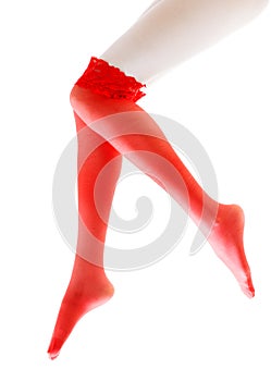 Sexy christmas card - woman with long beautiful legs in red stockings on winter background