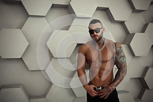 closeup topless portrait of Elegant handsome male model with fashion tattoo and a black beard standing and posing