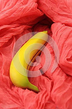 Sexy concept with banana on pink textile. Selective focus