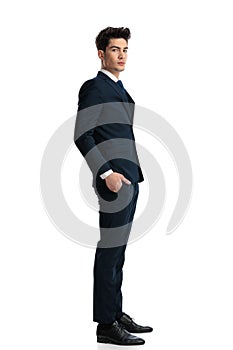 sexy confident businessman holding hands in pockets and standing in line