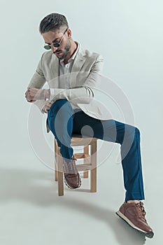 Sexy cool businessman with retro sunglasses looking down and posing