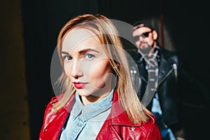 Sexy couple in leather jacket and sunglasses posing on city street