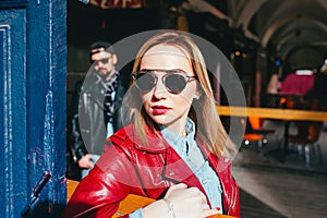 Sexy couple in leather jacket and sunglasses posing l on city street in sunny day