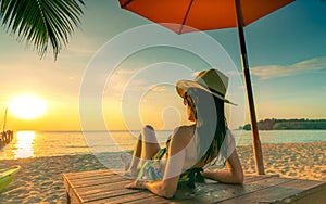 Sexy, enjoy and relax woman wear bikini lying and sunbathing on sunbed at sand beach at paradise tropical island beach