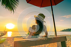 Sexy, enjoy and relax woman wear bikini lying and sunbathing on sunbed at sand beach at paradise tropical island under beach