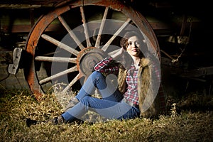 farm girl posing in front of rustic wagon in barn