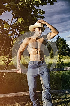 farmer or cowboy next to hay field