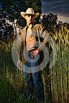 Sexy farmer or cowboy with unbuttoned shirt