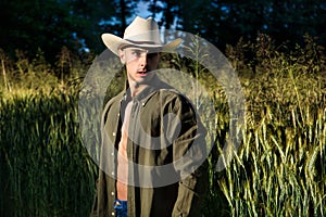 Sexy farmer or cowboy with unbuttoned shirt