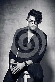 fashion man model dressed casual wearing glasses posing dramatic against grunge wall