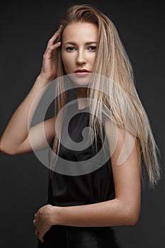 fashion model with long hair, young European attractive, beautiful eyes, perfect skin is posing in studio for