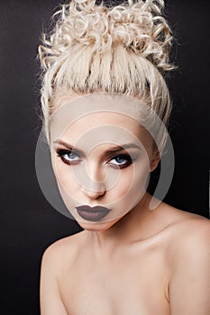 Sexy female blonde with smoky eyes and dark lips posing