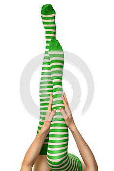 Sexy female long legs in green striped stockings. Leprechaun girl, isolated on white