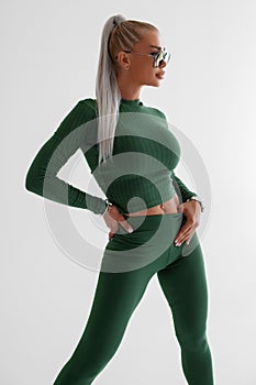 Sexy fitness woman. Beautiful athletic girl in green leggings