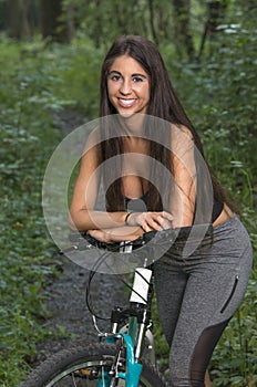 Sexy fmeale mountain biker in shade of forest - summer