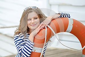 Sexy girl against wooden wall in the form of sailors with a lifeline and a cap. Shooting in the studio on a white